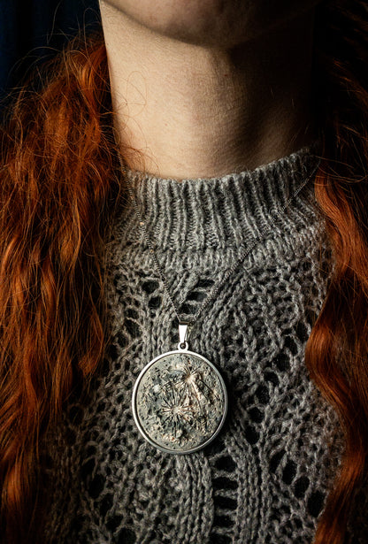 collana indossata da una donna a forma di luna 